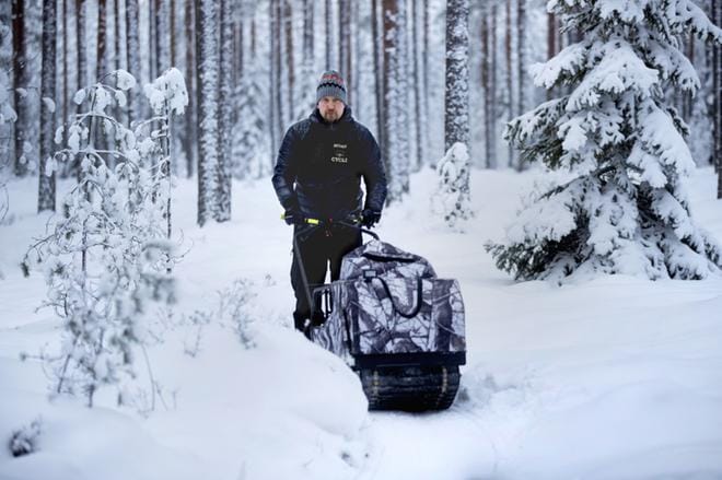 Tuukka Kuosmanen ajaa leveää uraa Jouppilanvuoren lumiseen maastoon telakoneella. Kuva: Jouko Hänninen