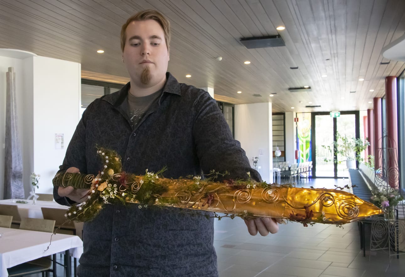 Ville Lapinoja esittelemässä Roosa Mikkosen tekemää kukkamiekkaa.