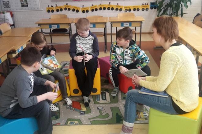 Suvi Lähdeaho esittelee toisille Ruonan koulun ekaluokkalaisille omaa kissakirjaansa. Kuuntelemassa ovat opettaja Heli Neulaniemen lisäksi Mikael Kontola (vas.), Juho Knuuttila ja Eelis Vainionpää. KUVA: ELLA NURMI