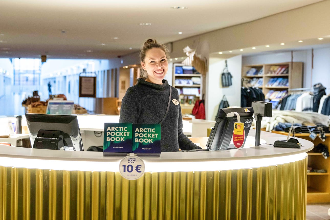 Arktikum Shop sijaitsee lipunmyyntipisteen yhteydessä. ”Jokainen on tervetullut ostoksille. Vierailla voi ilman näyttelylippua”, huikkaa kaupan vastaava Rosa Porsanger hymyillen.
