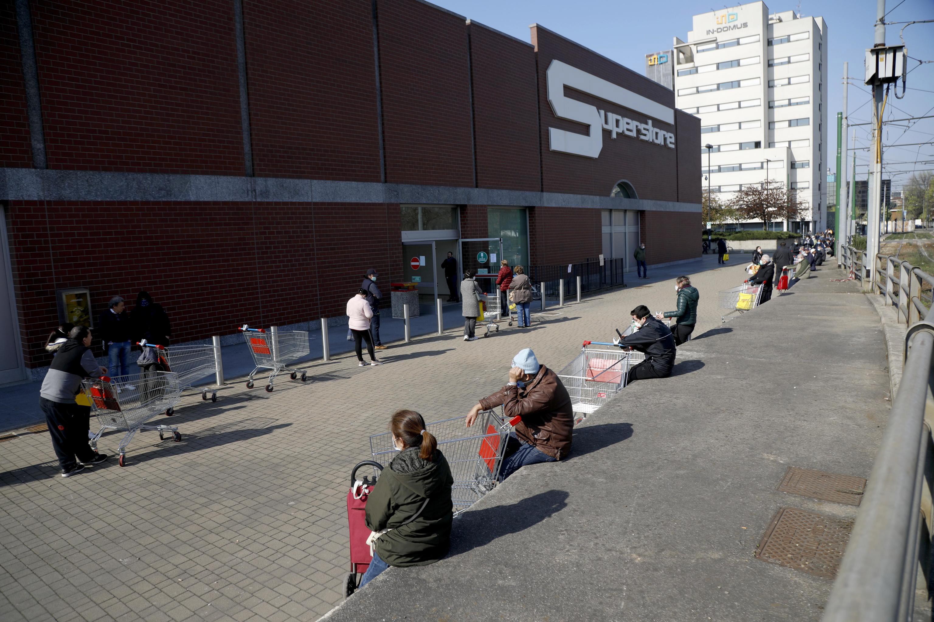 Italialaiset jonottivat lauantaina kauppakeskuksen ulkopuolella Milanossa.