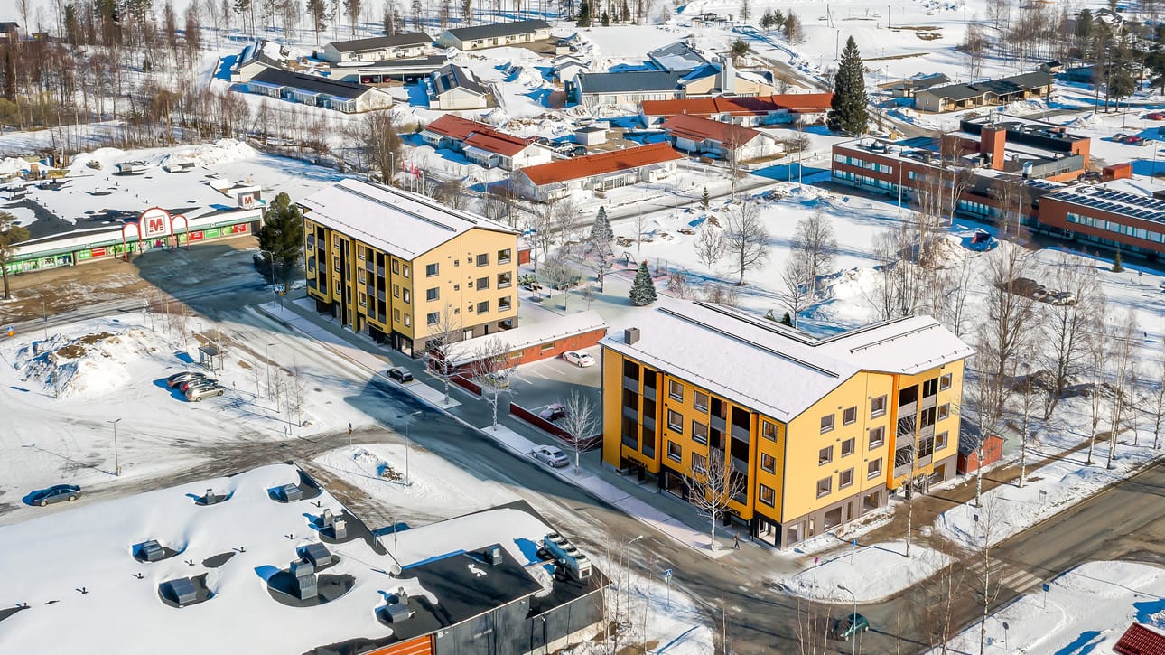 Kurenalustan ilme muuttuu kahden hirsikerrostalon valmistumisen myötä. Näkymä kerrostalojem suuntaan Varsitieltä päin. Talojen taakse kuvassa oikealle jää kaupungintalo ja talojen edessä on S-market parkkipaikkoineen.