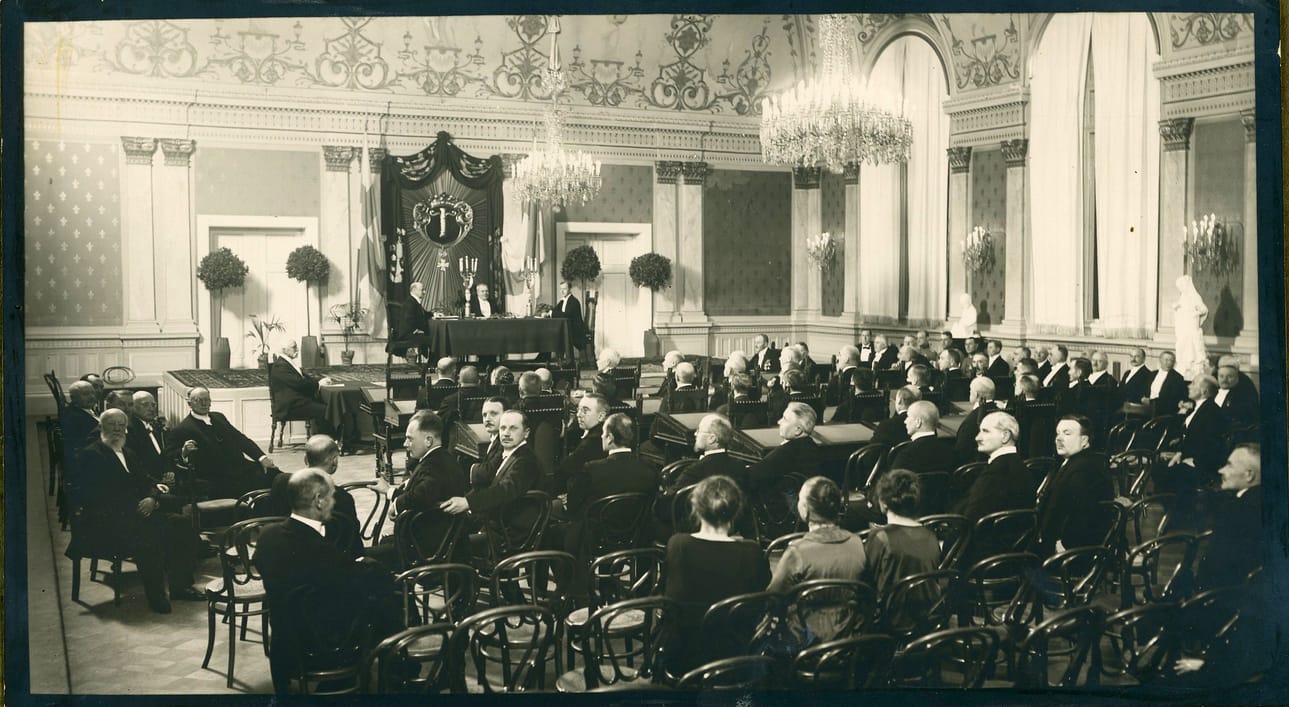 Vaasan kaupunginvaltuuston juhlaistuntoja on vietetty 25 vuoden välein vuodesta 1925 lähtien. Tässä on kuva siitä, valtuuston 50-vuotisjuhlaistunnosta 27.1.1925 eli 100 vuotta sitten. Valtuutetut istuvat pulpettien ääressä, varavaltuutetut ja yleisö tavallisilla tuoleilla. Puheenjohtaja on juhlasalin korokkeella. Kaupunginvaltuusto kokoontui monet vuosikymmenet Vaasan kaupungintalossa. Arkistokuva.