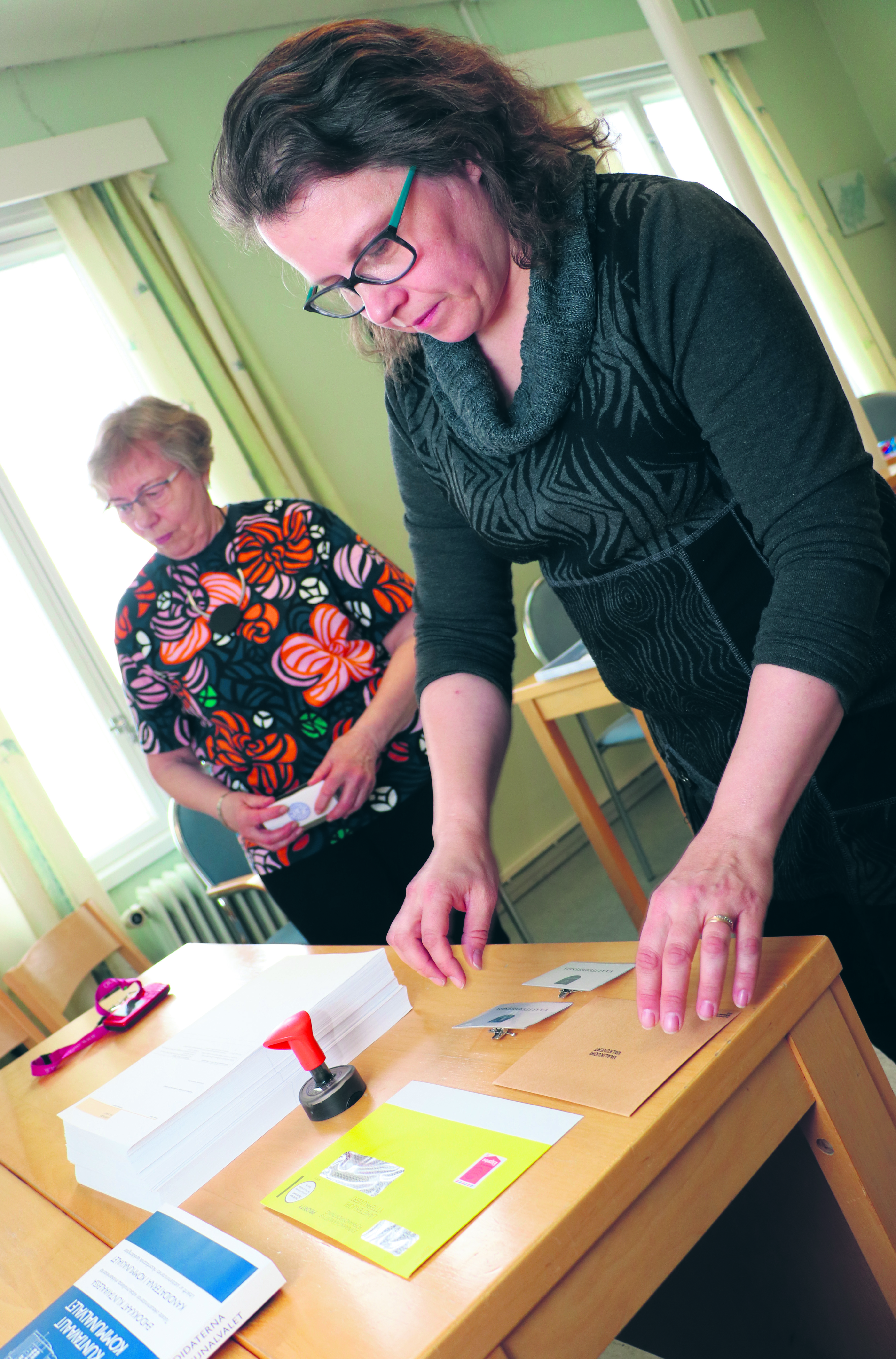 Lumijoen keskusvaalilautakunnan sihteeri Sari-Kaija Pernu ja puheenjohtaja Anna-Liisa Pottala järjestelevät äänestyspaikkaa kuntoon.