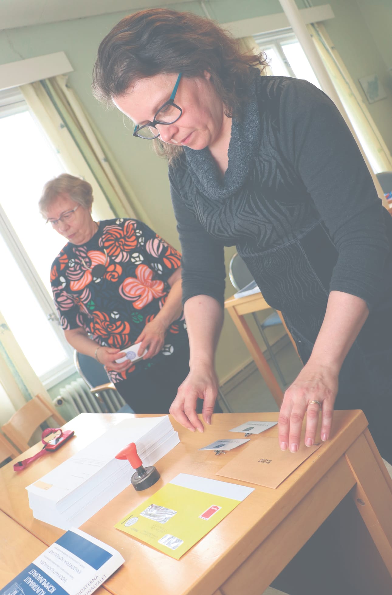 Lumijoen keskusvaalilautakunnan sihteeri Sari-Kaija Pernu ja puheenjohtaja Anna-Liisa Pottala järjestelevät äänestyspaikkaa kuntoon.