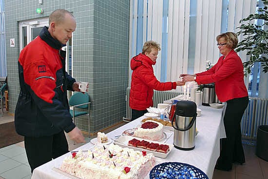 Ylivieskalaiset Veijo Honkaniemi ja Marja Sipilä nauttivat juhlakahvit 70-vuotiaan Kansaneläkelaitoksen Ylivieskan toimistossa. Kahvia heille tarjoili toimiston siivooja Raija Eskola. Honkaniemi asioi Kelassa harvoin, Sipilällä sen sijaan on usein käyntiä toimistossa.
