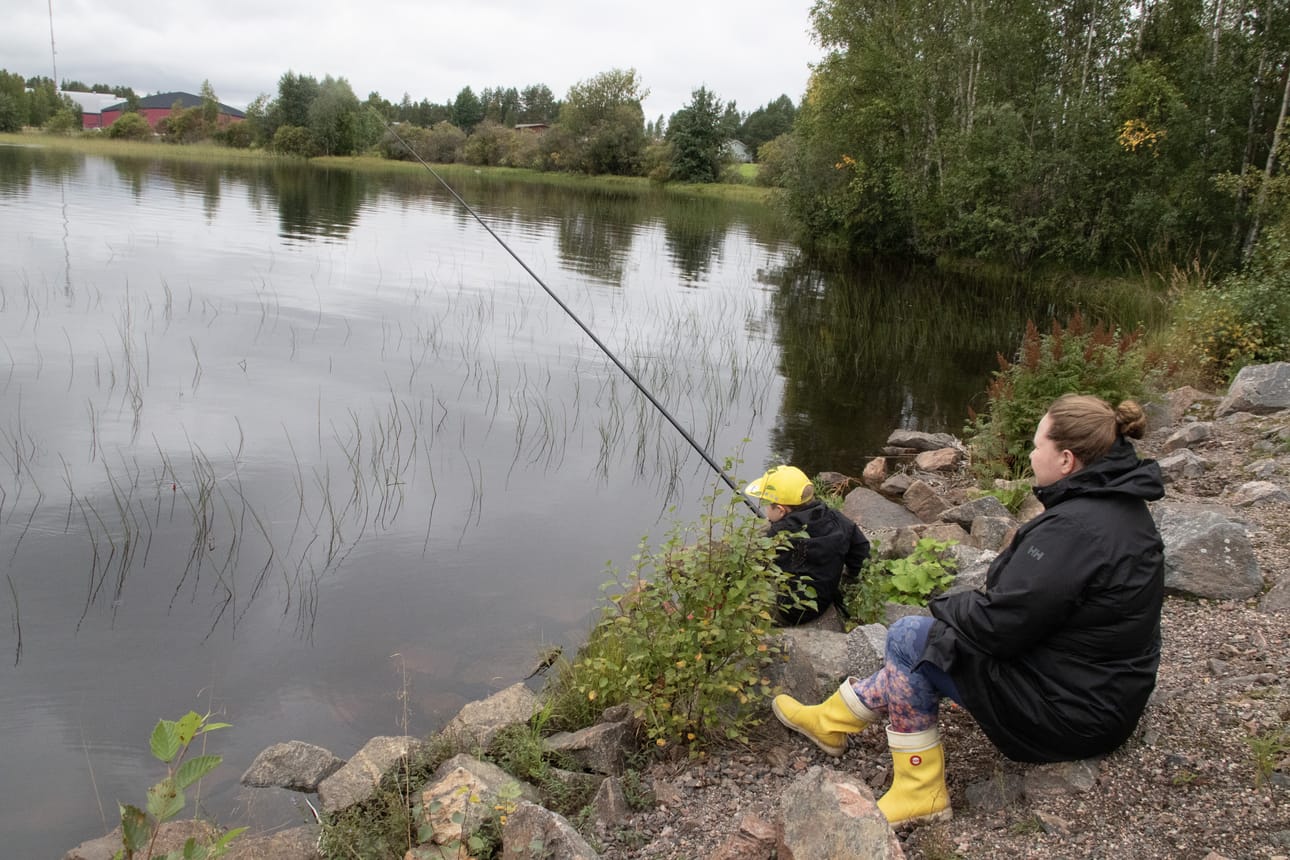 Liukkailla rantakivillä kalastaminen vaati hyvää tasapainoa. Elina Mastokangas seurasi rantakivellä istuen Eemelin kalastamista.