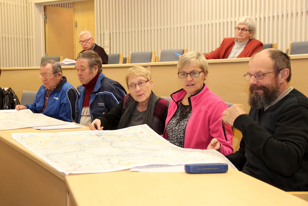 Rauno ja Hilkka Honkanen sekä Anja Salminen, Pekka Niemitalo ja Urho Mäntykenttä etsivät Pudasjärven yhteismetsään liittämiään palstoja perustamiskokouksessa esillä olleista kartoista. Taustalla yhteismetsän sääntöihin perehtyy Anneli Määttä.