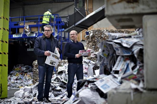 Jyrki Torpisto ja Lauri Törrö seisovat hallissa, jossa näkyy illan aikana käsiteltävä raaka-ainevuori. Taustalla on lajittelulinja, jolla sanomalehtipaperi erotellaan aikakauslehtipaperista. KUVAT: TOMI KOSONEN