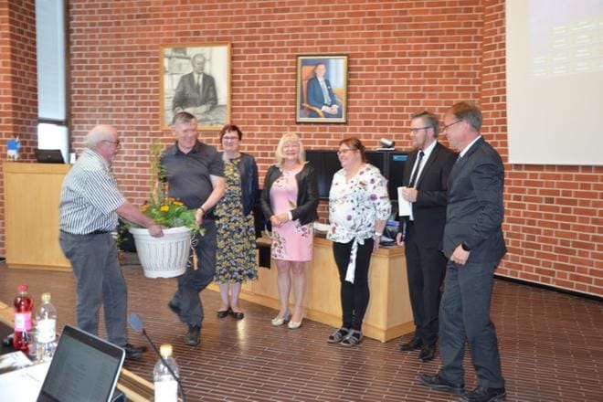Juhlahetki Alajärven valtuustossa. Valtuusto muisti 50 vuotta täyttänyttä kaupunginjohtaja Vesa Koivusta. Taustalla muotokuvissa tapahtumaa seuraavat Alajärven edelliset pitkäaikaiset kunnan- ja kaupunginjohtajat Jaakko Heinilä ja Kalevi Moisio. KUVA: SARI HEINILÄ