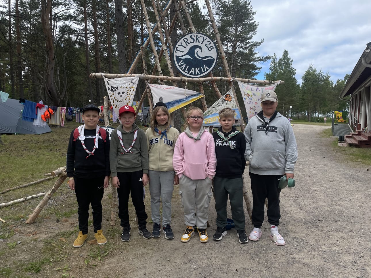 Seikkailijat Vilho Rytivaara, Otso Marjakangas, Väinö Lindelä, Vilho Pelkonen, Vili Heikkinen ja Huugo Syrjäpalo halusivat tulla kuvatuksi leiriportin edessä.