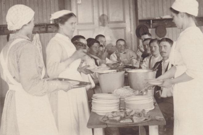 Kauhajoen seurakunnan sisar Eeva Pikkarainen (keskellä) jakoi soppaa ja oli mukana hoitotyössä Kauhajoen kenttäsairaalassa keväällä 1918. KUVA: Helsingin Diakonissalaitoksen arkisto