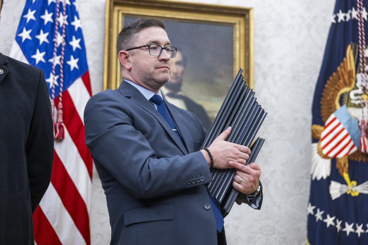 Virkaanastujaispäivän virkatehtäviin kuului urakka allekirjoittaa 26 hallintomääräystä ja muita Trumpin päätöksiä. Avustaja kantaa Valkoisen talon työhuoneeseen Oval Officeen kansioita. Kasassa olivat armahdukset tammikuun 6. päivän 2021 mellakoitsijoille ja Tiktokin kieltämisen lykkäys. Kuva: JIM LO SCALZO / POOL