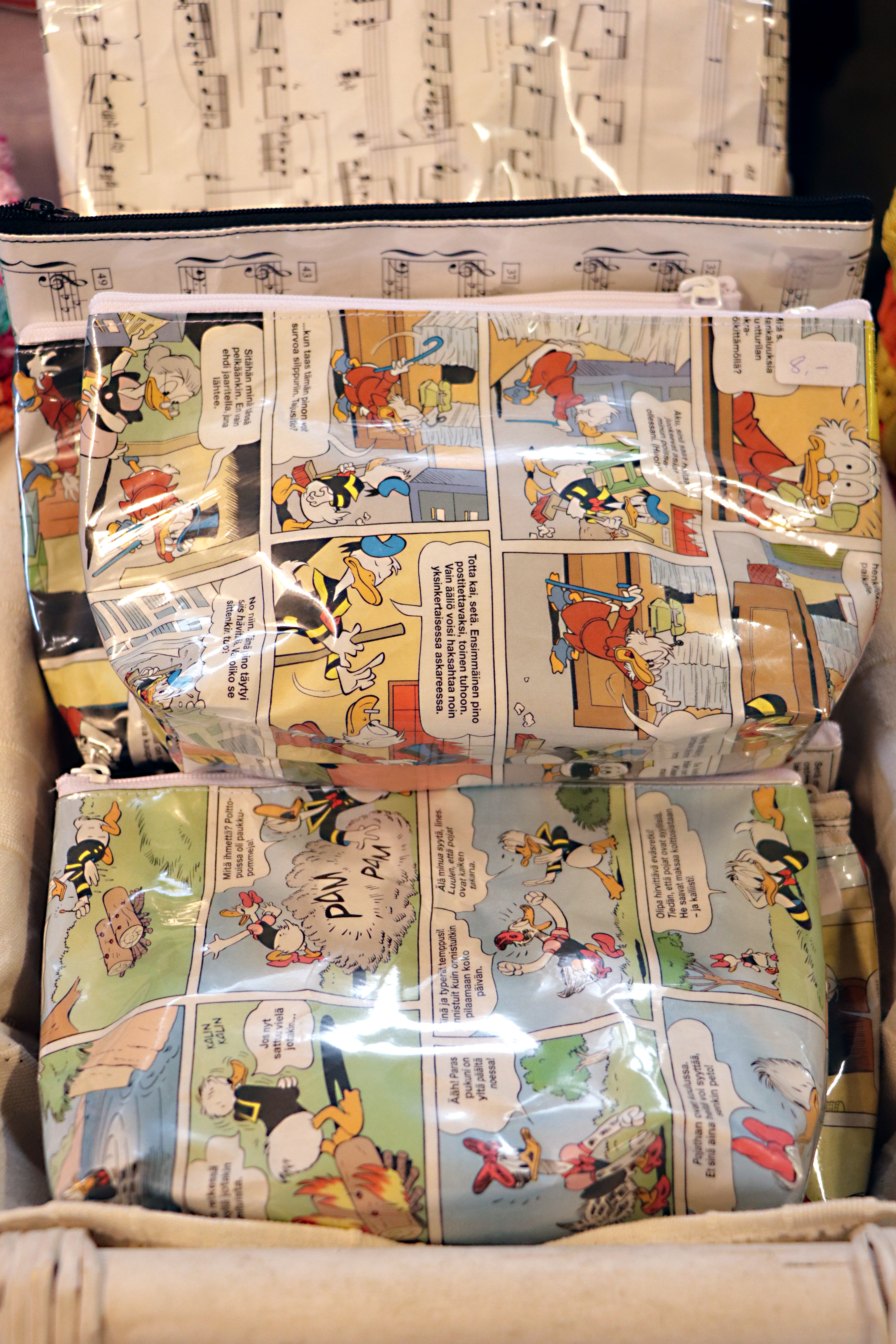 Kierrätystä tämäkin. Vanhoista Aku Ankoista ja nuottikirjan lehdistä valmistettua pussukkaa voi käyttää kynäpenaalina tai meikkipussina.