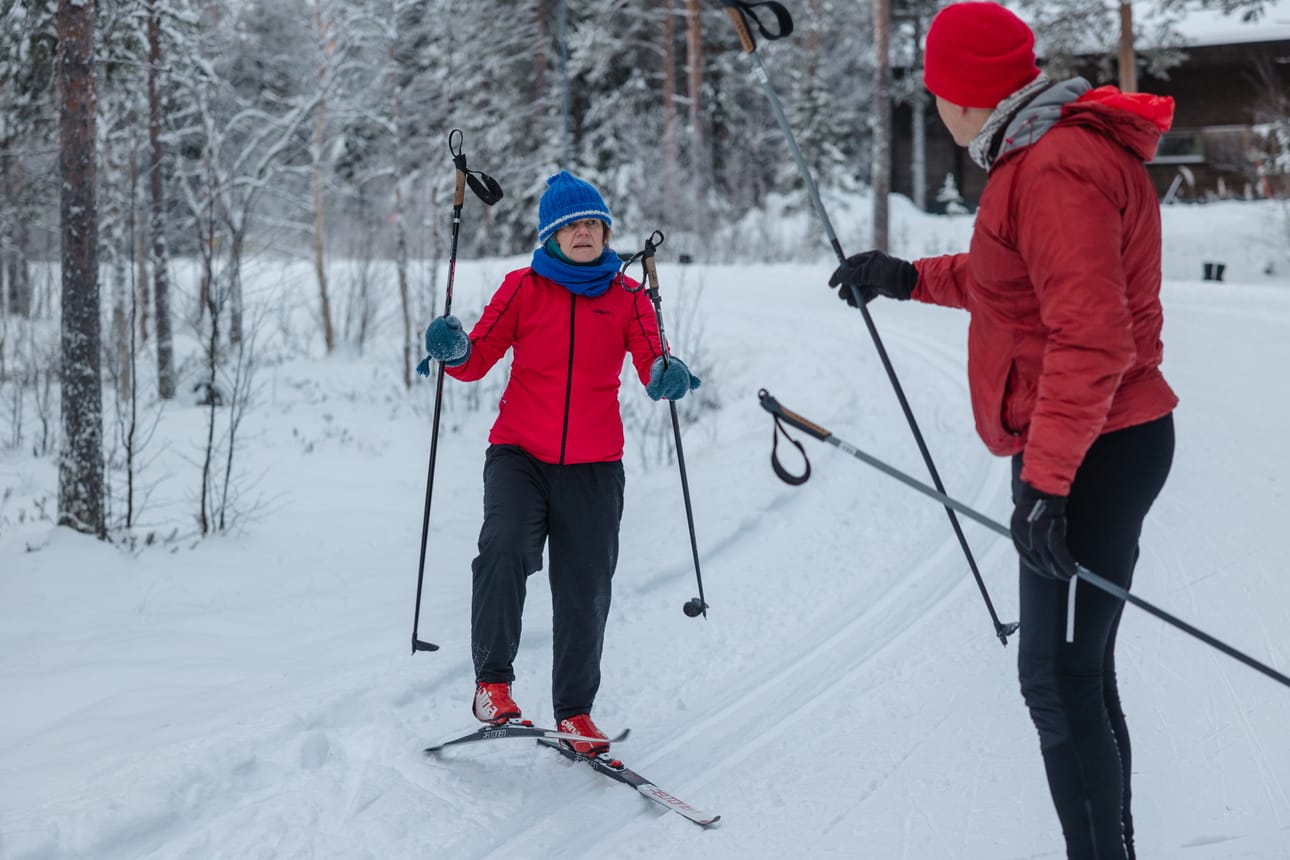 Opettaja Jani Vaattovaara opastaa Erika Benkelle lämmittelyharjoituksia hiihtotuntia varten.
