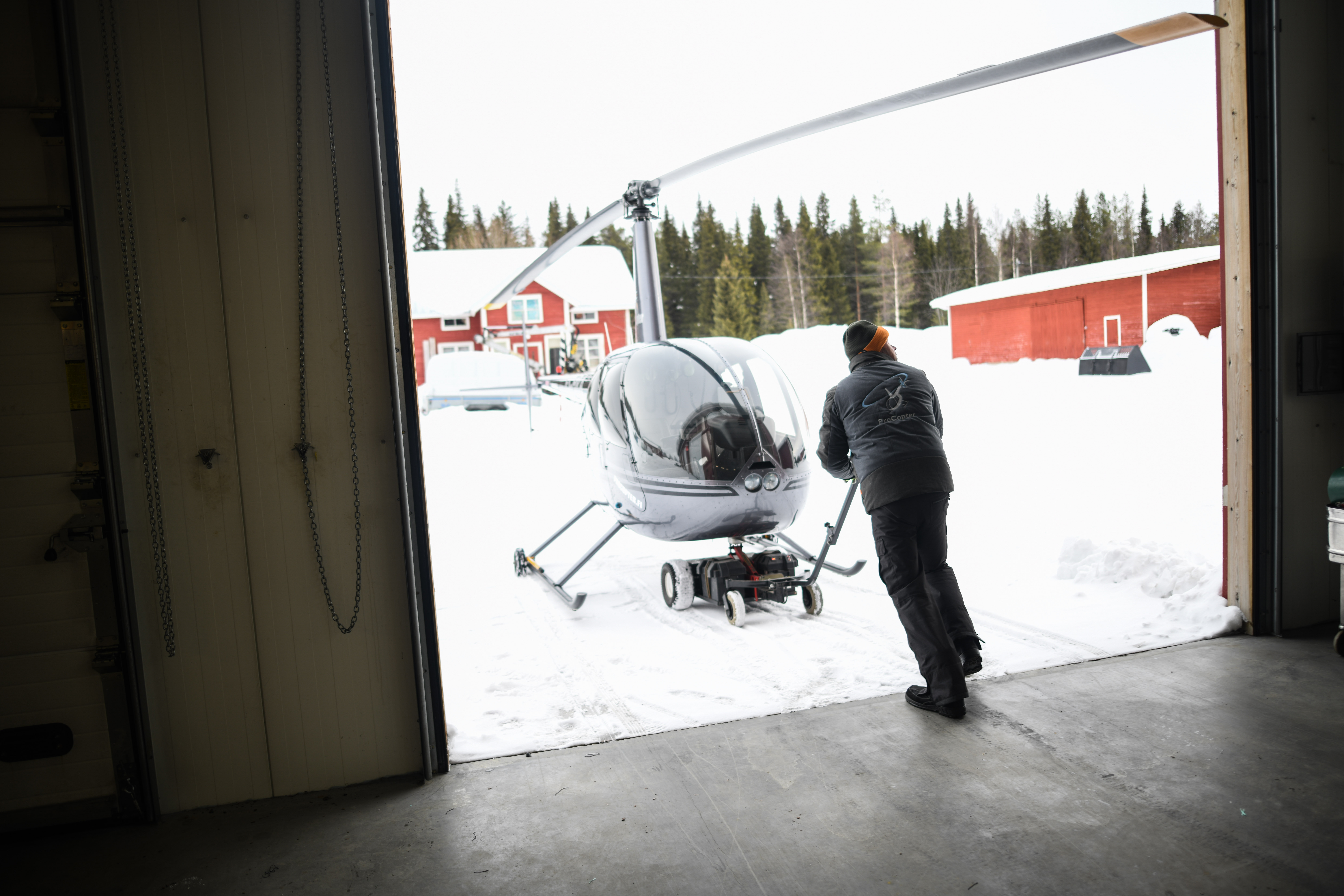 Noin 800 kilon painoinen kopteri siirtyy työntämällä hallista aamulla pihalle ja töihin.