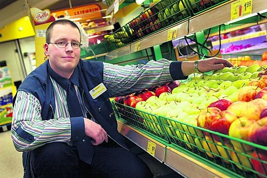 Kauppias Antti Lempiäinen laittaa omenahyllyä ojennukseen. Lempiäinen valmistautuu aloittamaan kauppansa loppuunmyyntiä haikealla mielellä.