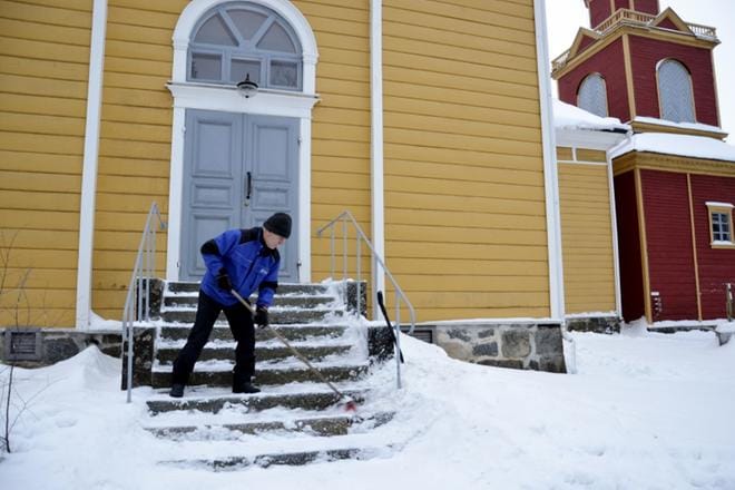Lehtimäen kauniin kirkon monet portaat seurakuntamestari Erkki Keisanen harjaa tarkasti lumesta puhtaaksi. KUVA: SAILA COLLANDER