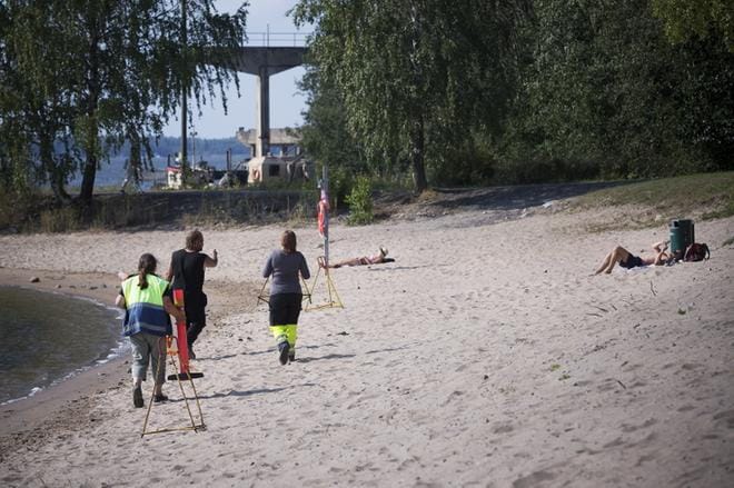 ▲ Kaupungin työntekijät veivät Mansikkasaareen eilen kieltokyltit. Uimaranta on toistaiseksi suljettu.