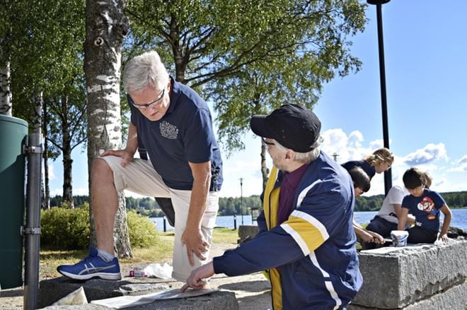 Arto Hakola (vas.) neuvoo Aarre Välisaarta kiven murskaamisessa. Työkalut ovat yksinkertaiset: Vasara tai leka ja muovipussi, johon kivet laitetaan murskattavaksi. KUVAT: JUHO KORPELA