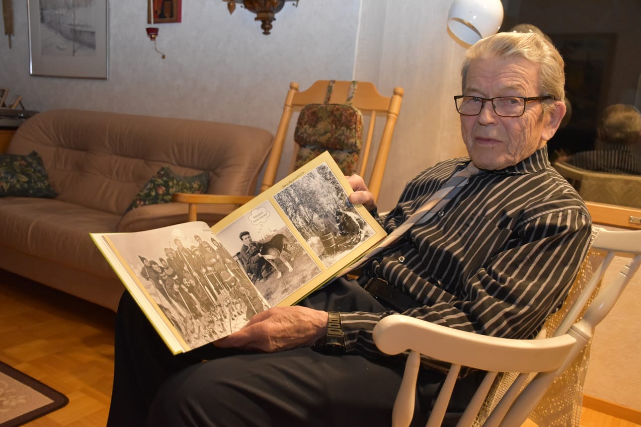 Työuransa Posiolla opettajana ja koulunjohtajana tehnyt Olavi Myllylä katselee hänestä koottua kuvakirjaa, jonka Olavin tyttären mies on koonnut.