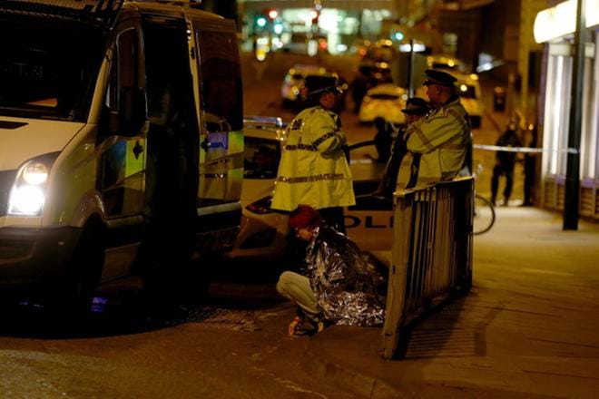 Nainen istuu Manchesterissa kadulla konsertti-iskun jälkeen. KUVA: Nigel Roddis/EPA