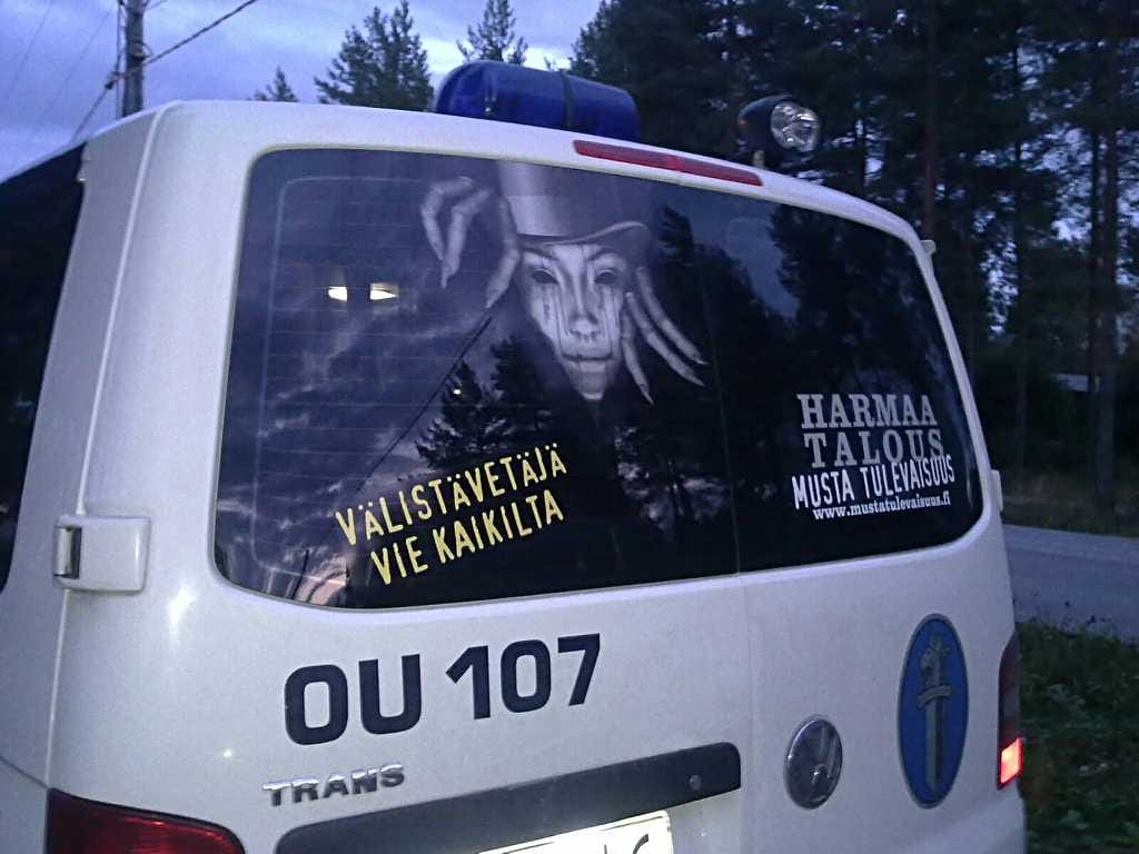 Harmaa talous -kampanja näkyy poliisiautojen takalasissa.