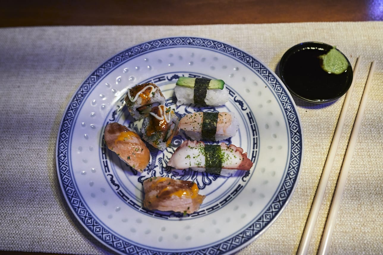 Hai Longin sushibuffetissa on tarjolla on erilaisia kala- merenelävä- ja kasvissusheja, joita on koristeltu ja maustettu erilaisin kastikkein.