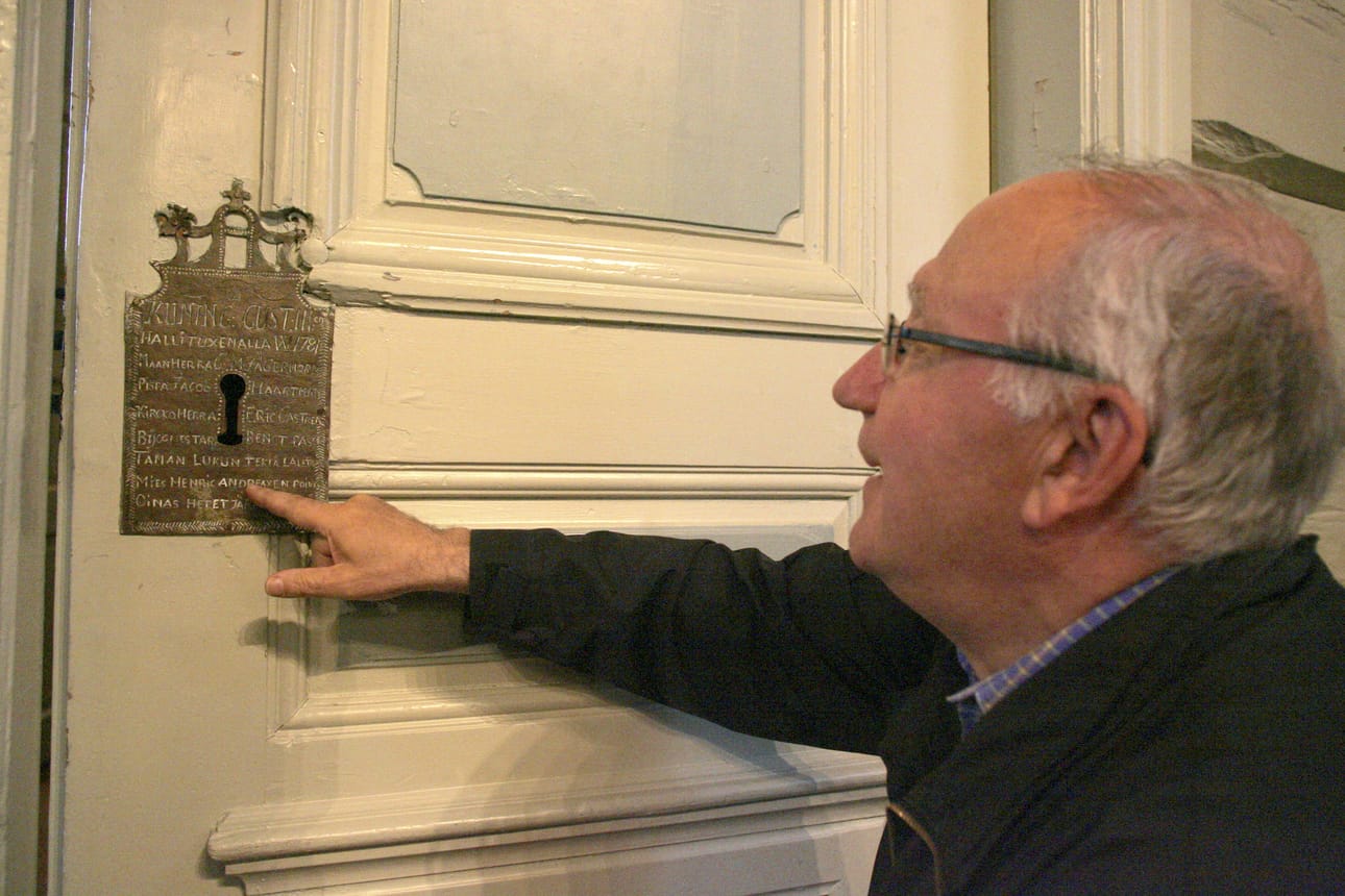 Erkki Piri kertoo sakastin oven lukon koristeen kertovan Pudasjärven kirkon historian.