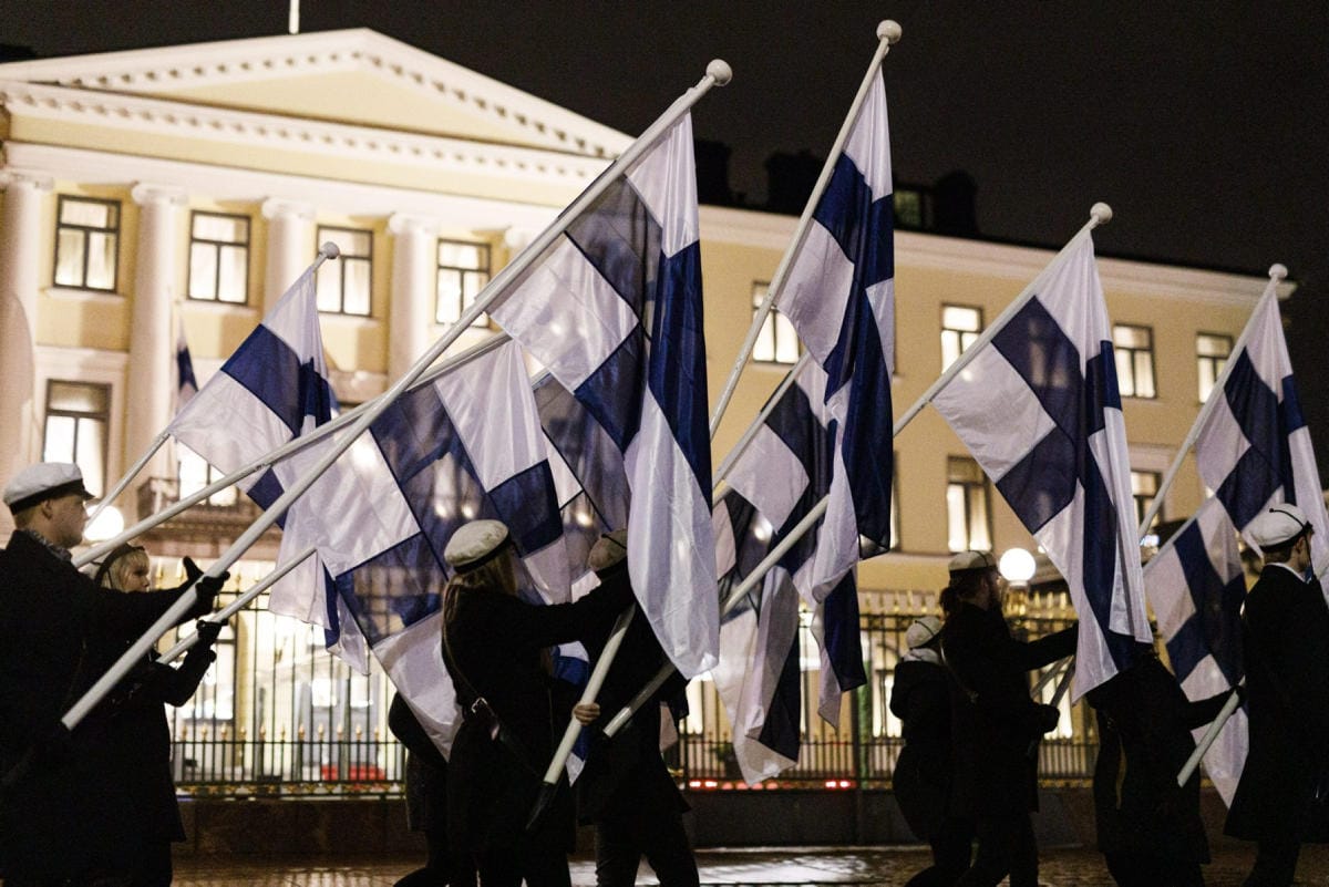 Suomen lippuja ylioppilaiden soihtukulkueessa Presidentinlinnan edustalla Helsingissä itsenäisyyspäivänä 6. joulukuuta 2019. LEHTIKUVA / RONI REKOMAA
