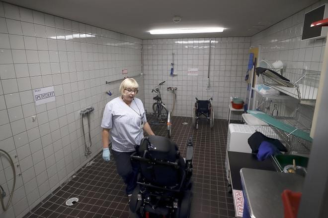 Sairaalahuoltaja Maritta Vainionpää puhdistaa välineitä apuvälinekeskuksessa. Työtila on erityisen hankala ja ilma surkea. Viemärit haisevat, eikä ovea voi pitää auki käytävälle. KUVA: HEIKKI HAKANEN