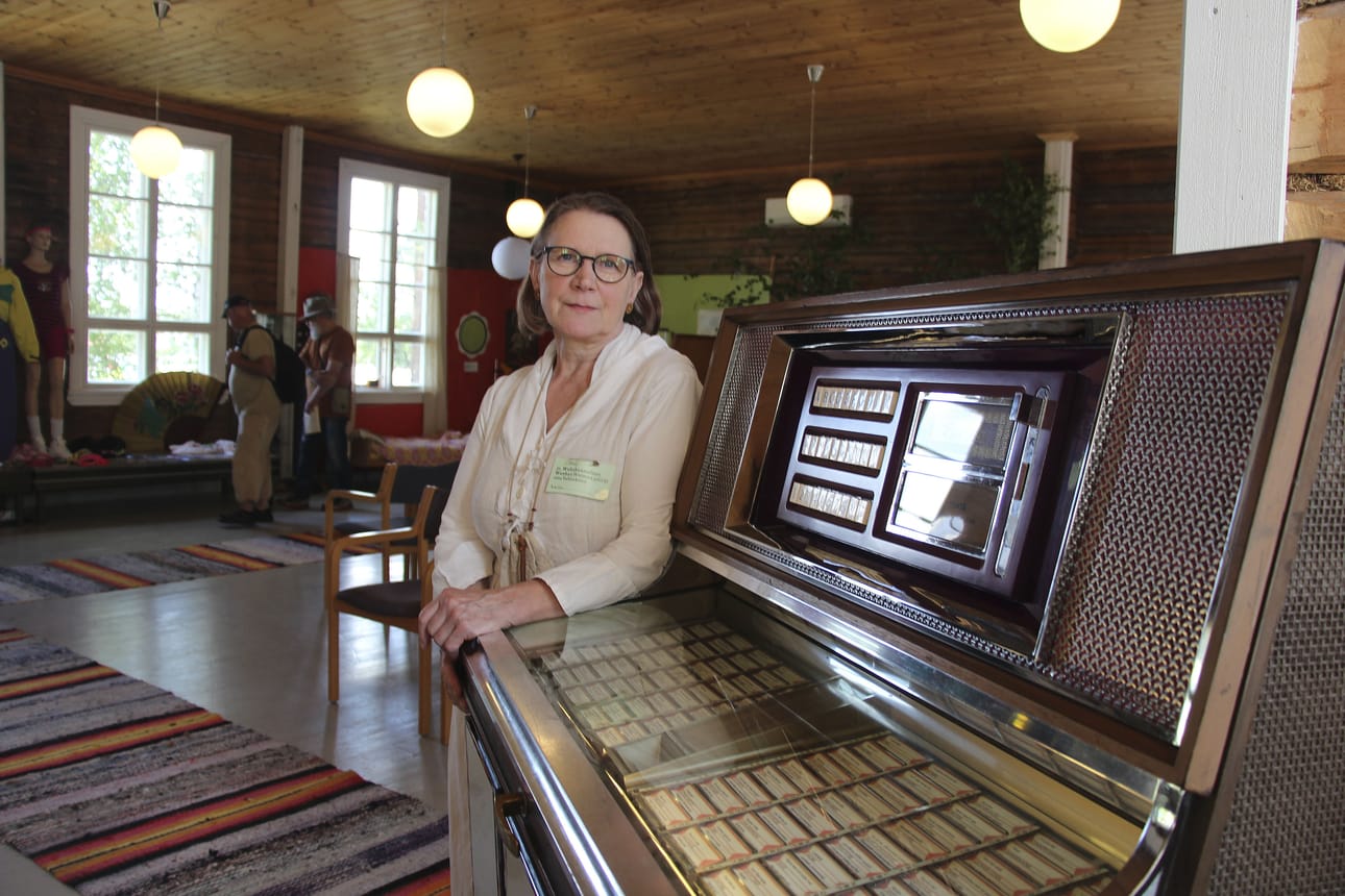 Naiswoiman Leila Laukkanen esittelee Ihana kamala nuoruus -näyttelyyn kuuluvaa, toimivaa jukeboksia. Näyttely on esillä noin kuukauden ajan Käpylän vanhalla koululla.