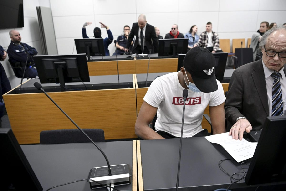 Toinen murhan syytetyistä (takana) elehti ja näytti käsimerkkejä Itä-Uudenmaan käräjäoikeudessa Vantaalla tiistaiaamuna 10. toukokuuta. LEHTIKUVA / MARKKU ULANDER