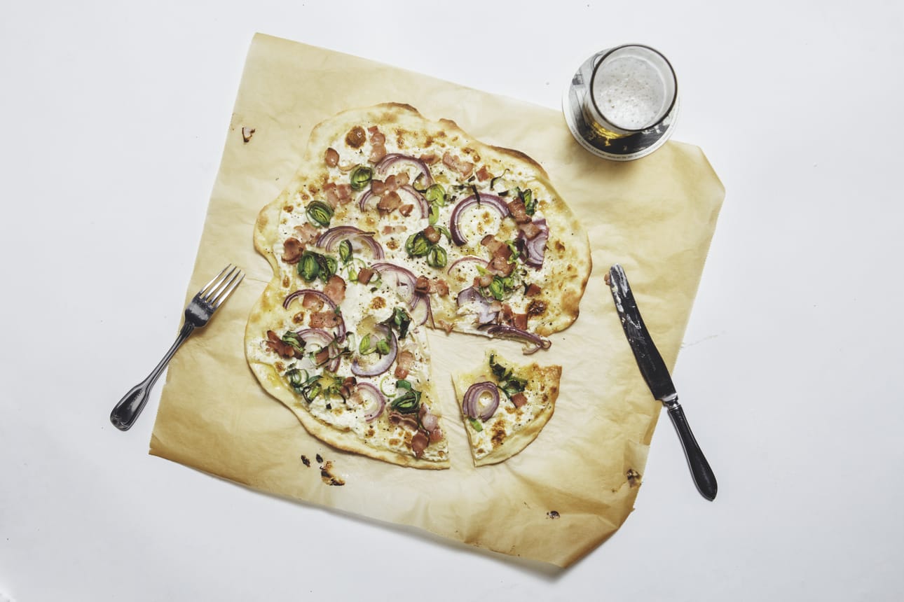 Pizzaa muistuttavan Flammkuchenin tekeminen on helppoa ja nopeaa. Pohja kaulitaan mahdollisimman ohueksi. Täytteen tarkoitus on olla mauste, ei pääasia. Kuva: Vilja Pursiainen