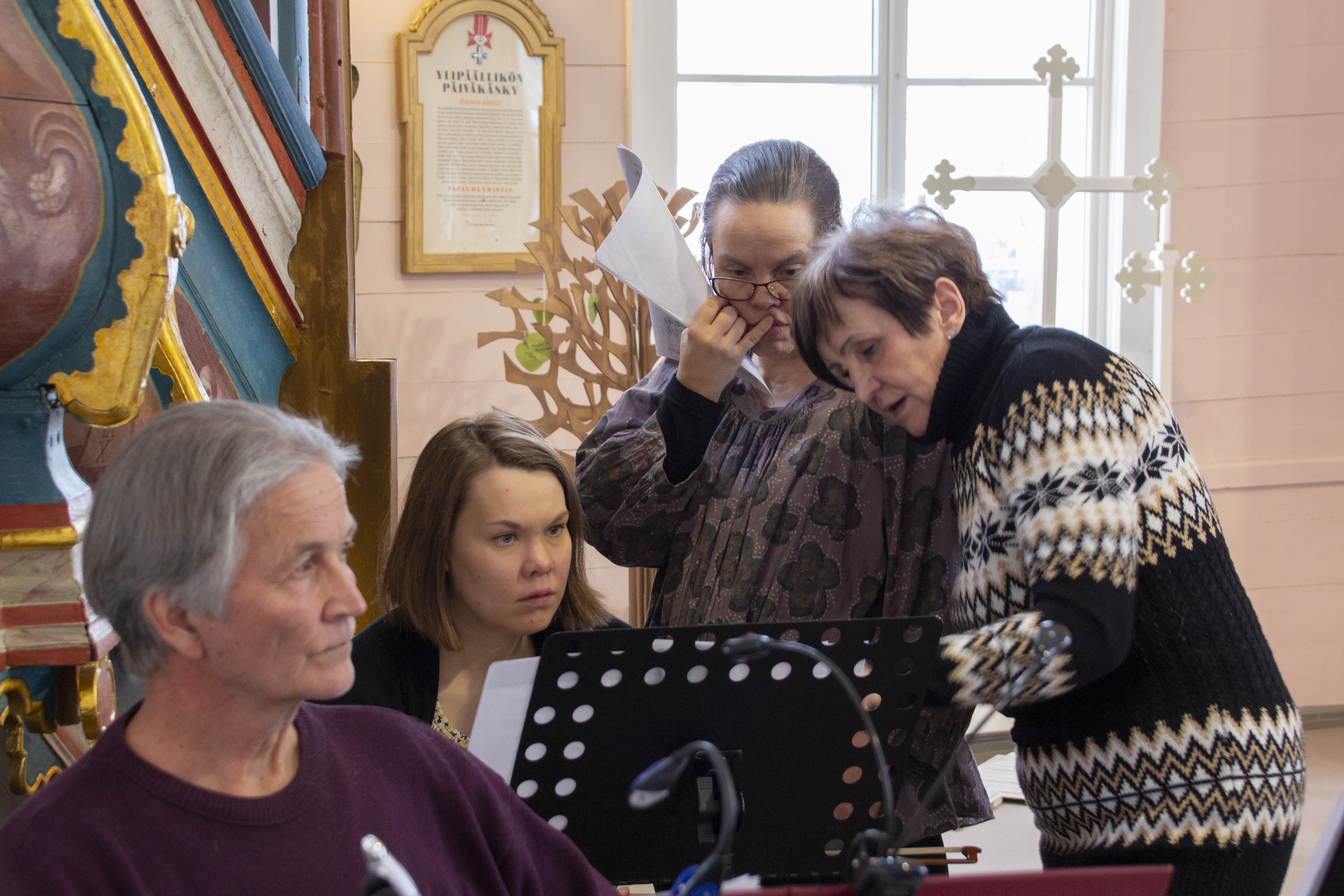 Kanttori Pekka Kyöstilä ja viulisti Jenni Myllylä ovat tuttu näky kuoron säestäjäjoukossa. Jenni, Sari ja Anne pohtivat kuvassa joululaulujen tarkempia sävelkulkuja. Heidän lisäkseen taustoja soittamassa on myös kitaristi Pekka Huhtala.