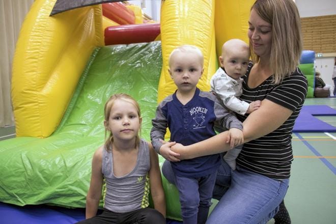 Jenni Saarelan sylissä ollut viiden kuukauden ikäinen Eemi-vauva seurasi ihmeissään, kun hänen sisaruksensa Jade ja Sasu peuhasivat salissa. KUVA: JORMA HAVULA