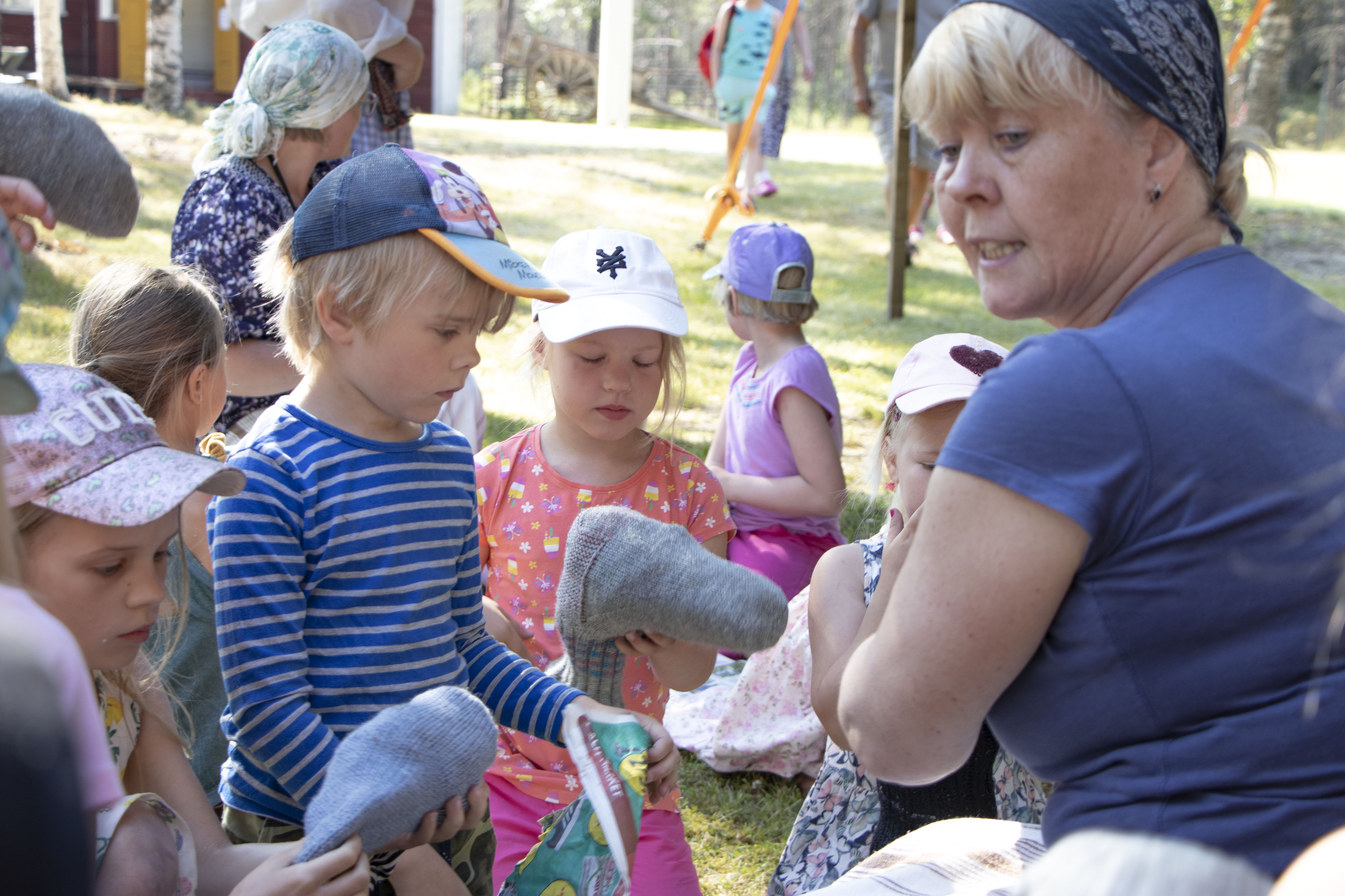 Liisa Saarikoski opasti lapsia, kuinka keppihevosen aihiona oleva villasukka täyteään sanomalehtipaperisilpulla.