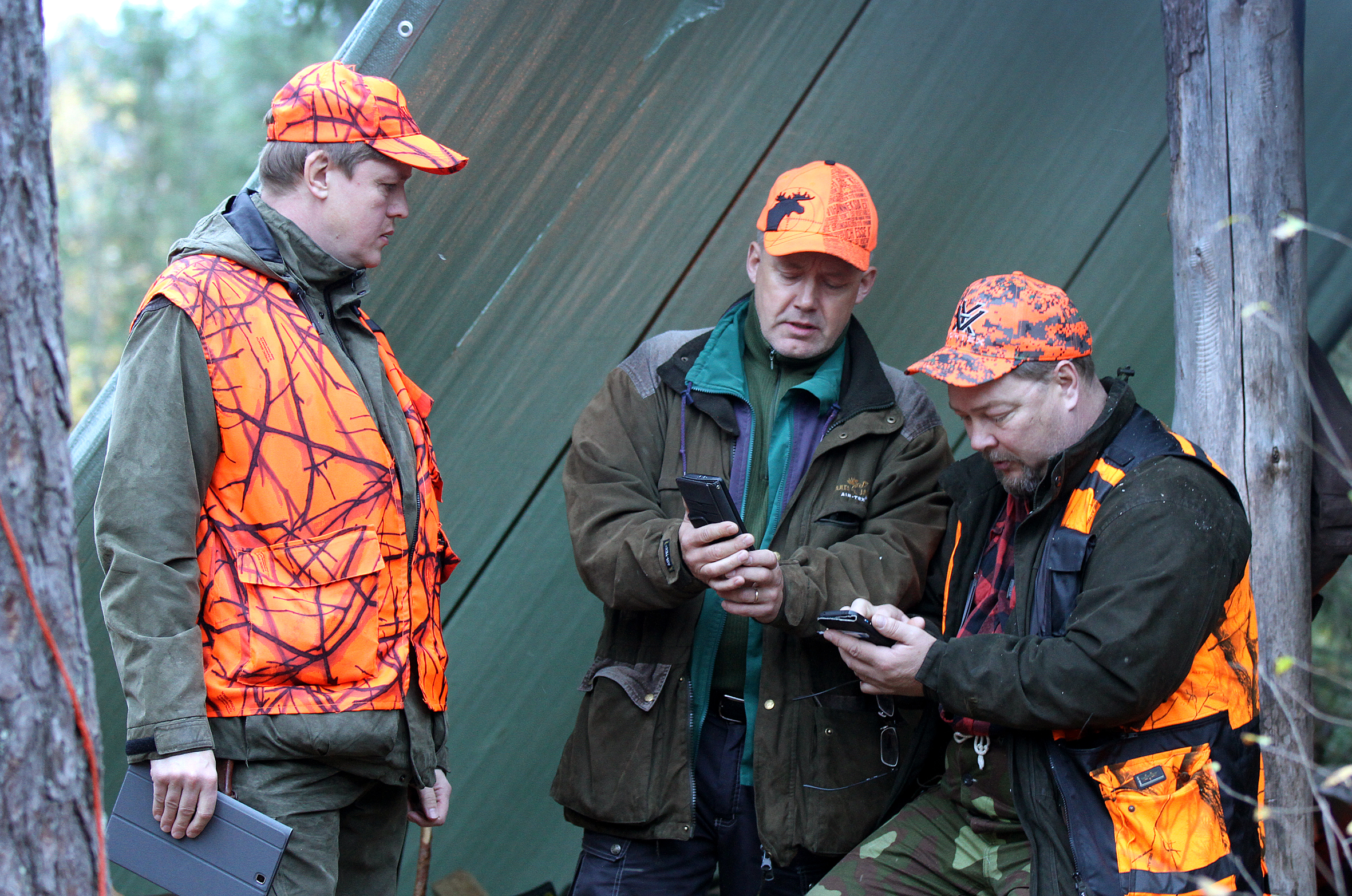 Älylaitteet ovat tulleet tärkeäksi osaksi metsästystä. Jaakko Mannermaa, Pauli Helin ja Markku Neuvonen tutkivat sähköisiä karttoja.