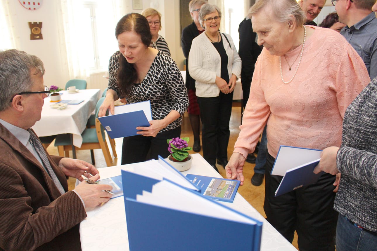 Maustajan kahdesta vuosikymmenestä kirjan koonnut Jukka Laurila jakoi kirjan julkaisujuhlassa omistuskirjoituksia. Kirjaa vastaanottamassa Arja Komulainen. Seuraavana vuorossa oli Taimi Huovinen joka lähti karjasta luopumisen jälkeen Einestuotteelle kesätöihin, joita riitti kahdeksan vuotta ennen eläkkeelle jäämistä.