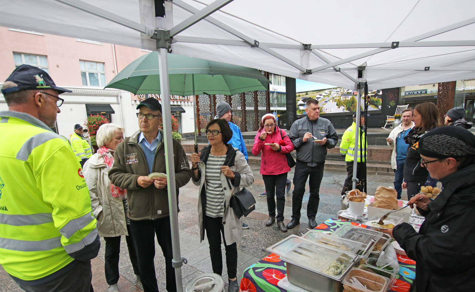 Markkinapäällikkö Jaakko Rahko (oikeanpuolimmaisessa kuvassa vasemmalla) kertoi tulevista markkinoista ohikulkijoille. Marika Keränen (oikealla) jakoi vieraille tyrnäväläistä aamupalaa.