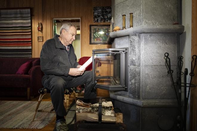 Puulämmitys on kesämökkien yleisin lämmönlähde. Tammelassa lomaileva Ilkka Kouri sytyttää tulet isoon vuolukivitakkaan. KUVAT: Lassi Puhtimäki