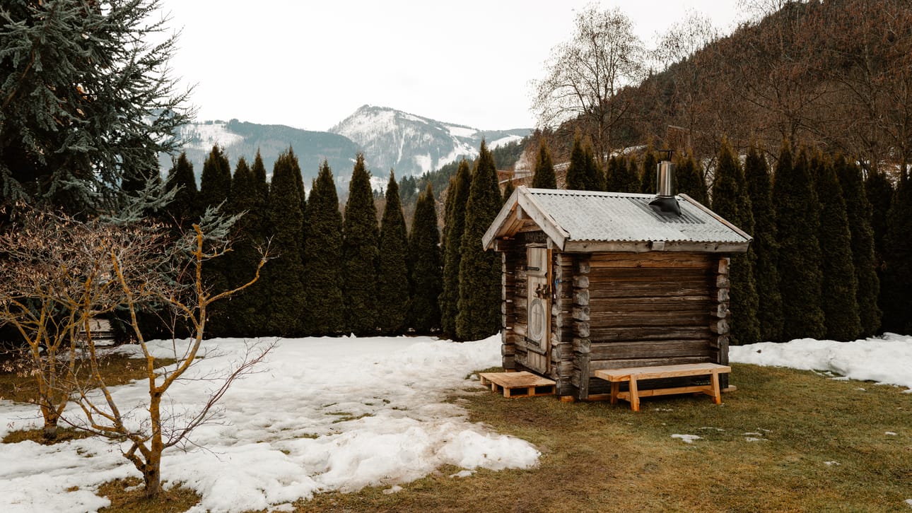 Pihan suojassa, vuorten katveessa. Tämä sauna kulki Suomesta rekalla linnuntietä 1 770 kilometrin päähän, jotta Suomen hiihtomaajoukkue saa kotimaiset löylyt.