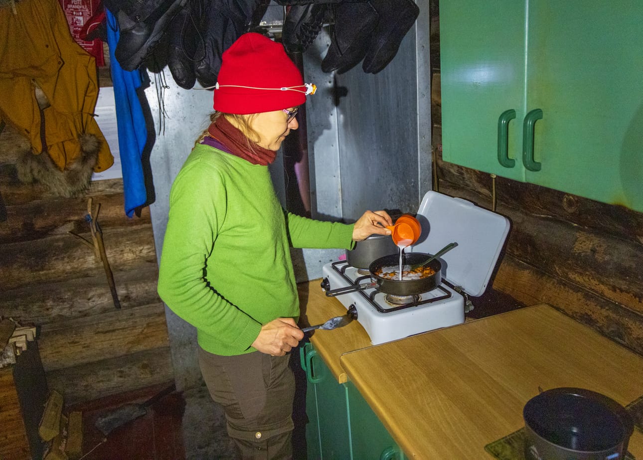 Ruoanlaittopuuhissa autiotuvalla. Ennen poislähtöä kaasuhana suljetaan ja mahdolliset ruoan roiskeet siivotaan liedeltä.