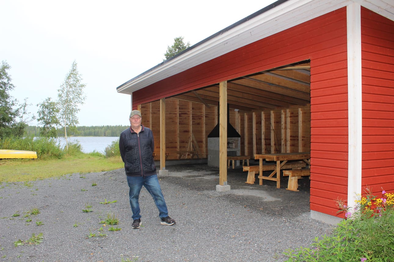 Pluumilla asuva Mauri Rajasalo arvioi, että uuden grillikatoksen rakentaminen maksoi kaikkiaan noin 20 000 euroa, jos mukaan lasketaan myös talkootyöt. Rajasalon taustalla juuri valmistunut katos. KUVA: LOTTA KALLIO