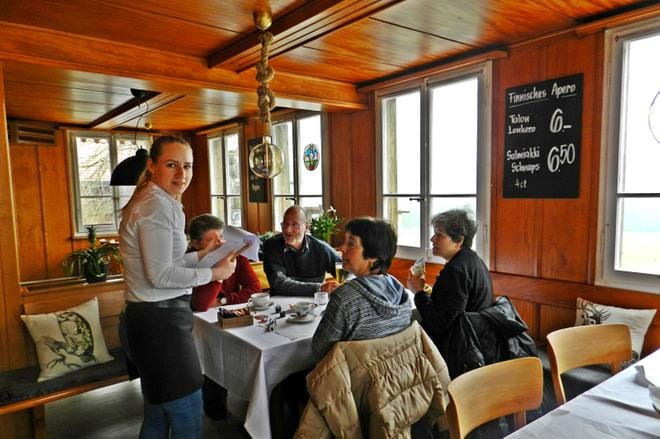 Emilia Lilja kyselee, mitä voisi tarjoilla Bruno Haasille, Fritz Gasserille sekä heidän rouvilleen Edithille ja Estherille. Isä-Arto on sekoittanut seinätauluissa mainostettavat lonkeron ja salmiakkikossun. 6 frangia vastaa noin 5 euroa.