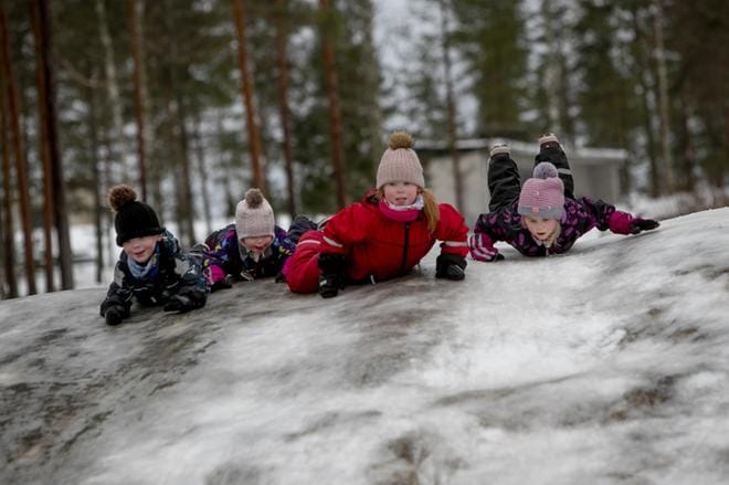 Elia Parhiala, Olivia Rynnäs, Minea Parhiala ja Minea Rynnäs laskivat Joupiskan jäistä pulkkamäkeä haalareissaan. Touhuilu oli niin hauskaa, että he eivät olisi malttaneet lähteä pois. Kuva: Jaakko Elenius