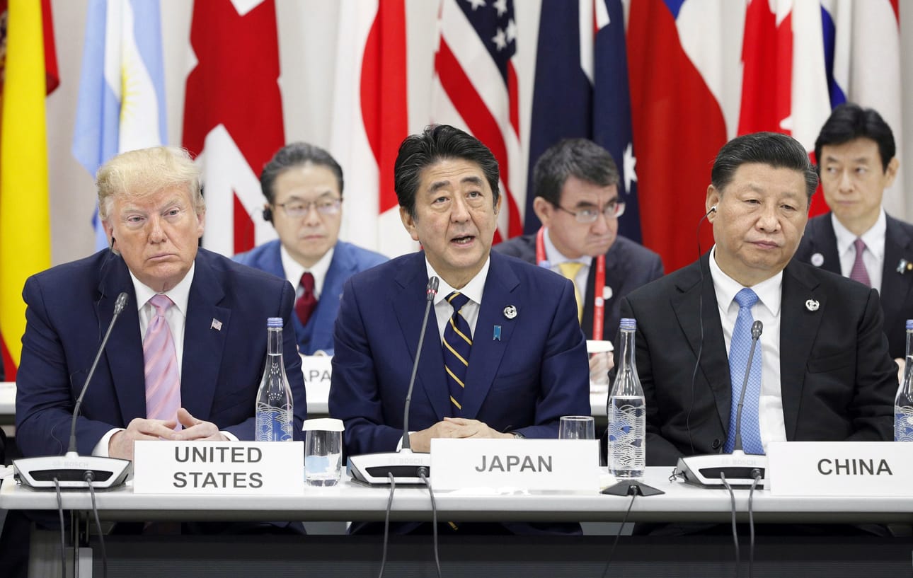 Donald Trumpilla (vas.) ja Xi Jinpingillä (oik.) ei hymy irronnut, kun Osakan kokouksen isäntä, Japanin pääministeri Shinzo Abe avasi G20-maiden kokouksen.