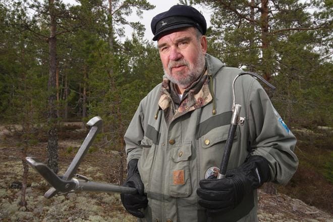 Urpo Koponen pitää aina saappaita jalassaan käärmemetsällä. Siirtäessään käärmeitä talojen pihoilta muualle hän käyttää viiltosuojakäsineitä, haarakeppiä ja haavia. KUVA: Tero Talvio
