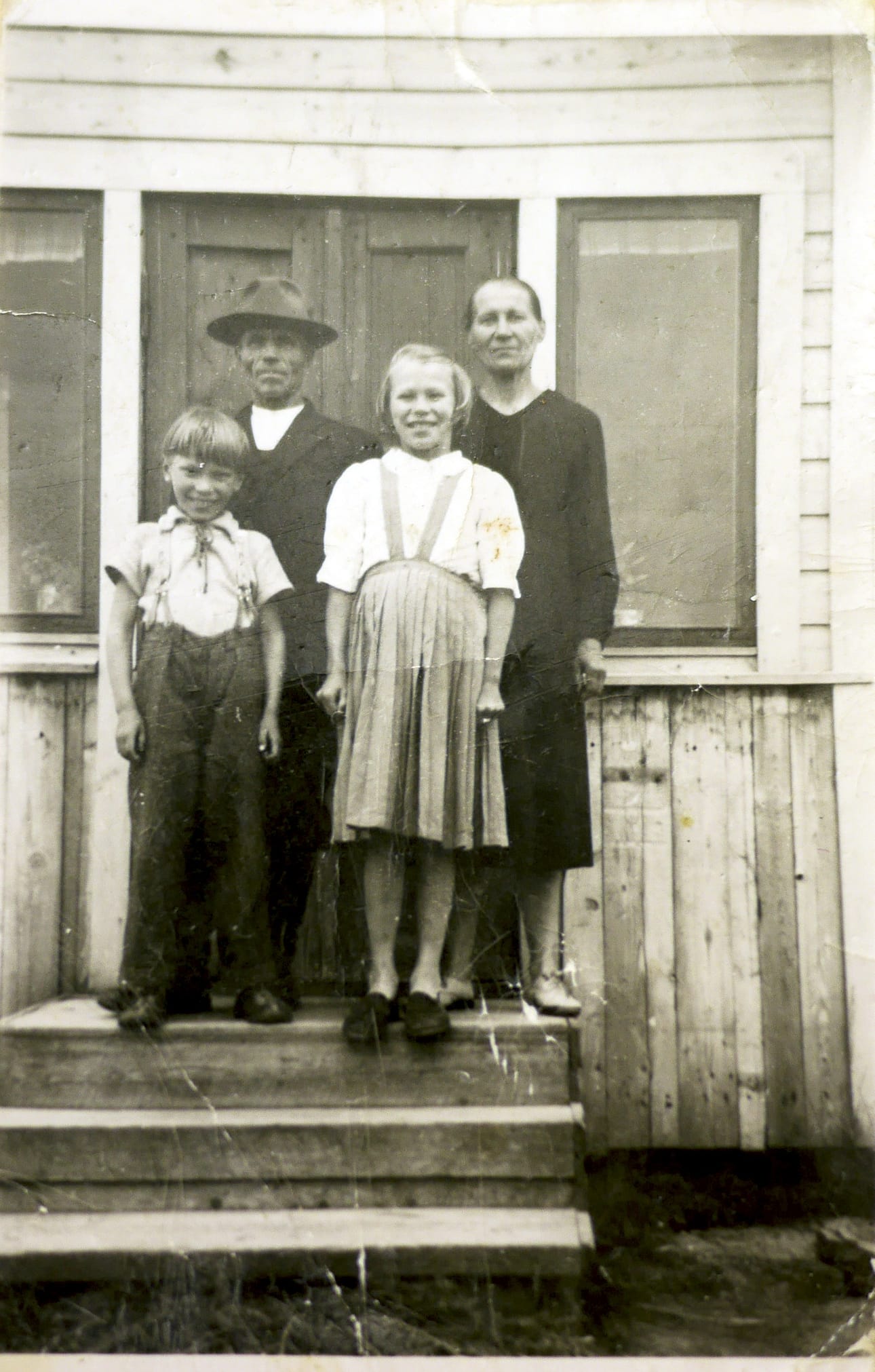 Kuva 1. Simo ja Iida Kovala tyttärensä Kyllikin ja poikansa Osmon kanssa kotitalonsa Pökkelöniemen portailla 1950-luvun puolivälissä. (Kyllikki Riekin kokoelma)
