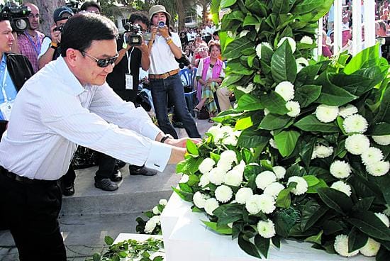 Thaimaan pääministeri Thaksin Shinawatra laskee kukkalaitteen vuoden takaisen tsunamikatastrofin uhrien muistolle Phuketissa eteläisessä Thaimaassa.